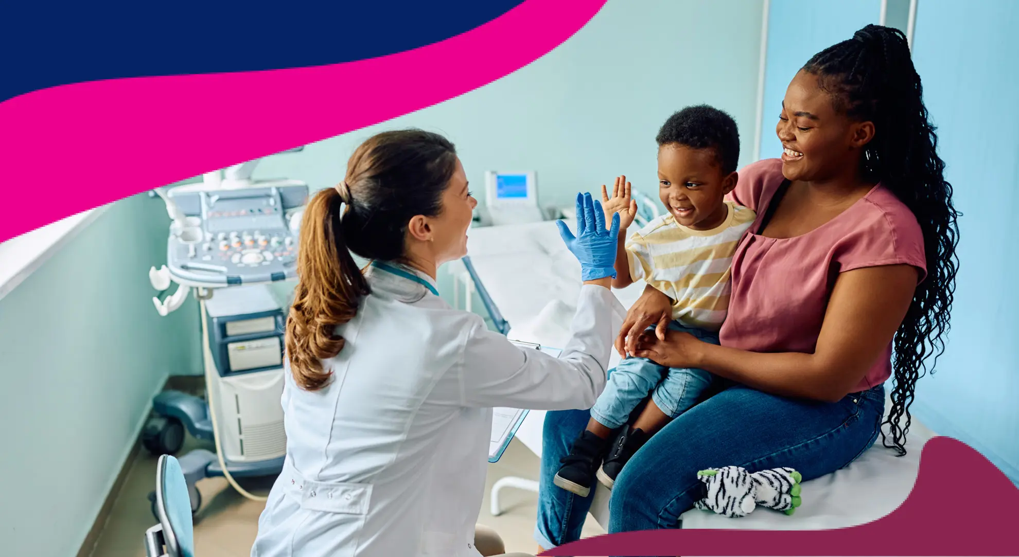 Doctor giving a high-five to young patient and his mother in a hospital room