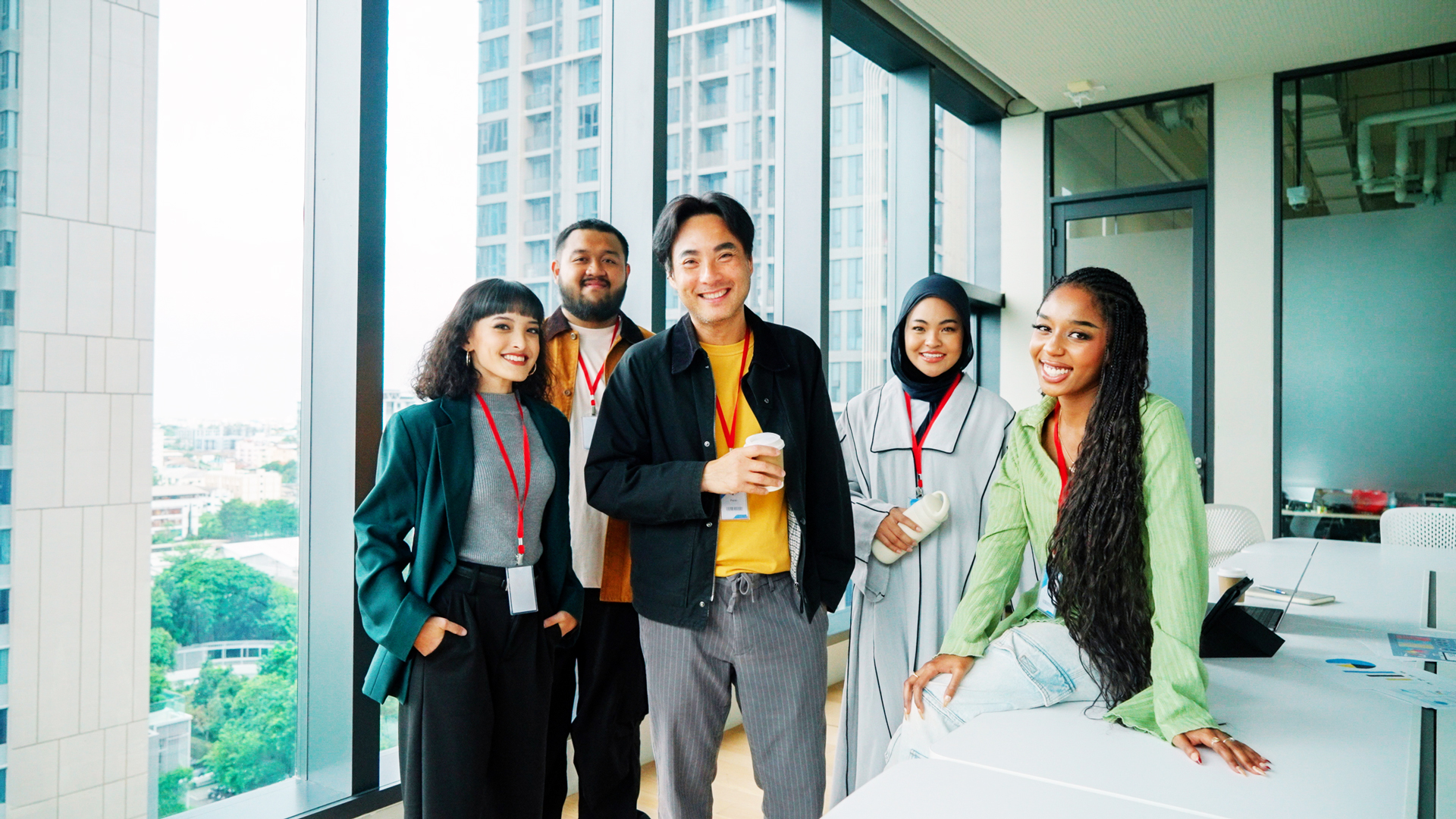 A group photo of young, diverse, office workers in a conference room